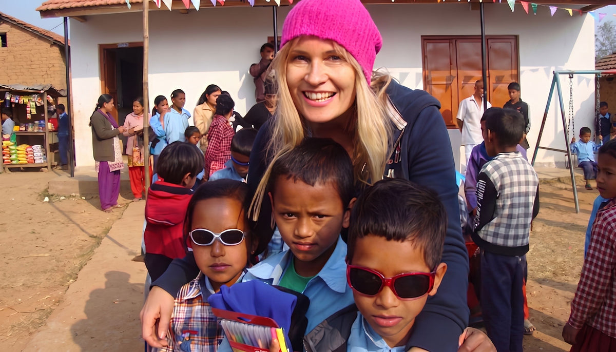 Madeleine mit pinker Mütze und Schulkindern in Nepal